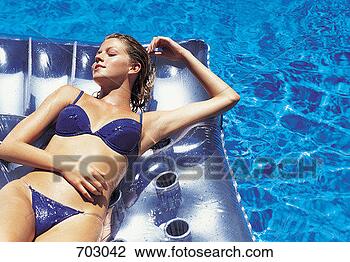 Stock Photo - woman relaxing 
on an inflatable 
in a swimming 
pool. fotosearch 
- search stock 
photos, pictures, 
images, and photo 
clipart