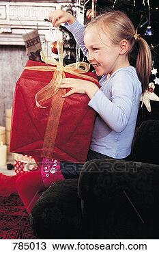 Stock Photo - girl unwrapping 
her christmas 
present. fotosearch 
- search stock 
photos, pictures, 
images, and photo 
clipart