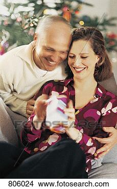 Stock Photo - mature couple 
unwrapping a christmas 
present. fotosearch 
- search stock 
photos, pictures, 
images, and photo 
clipart