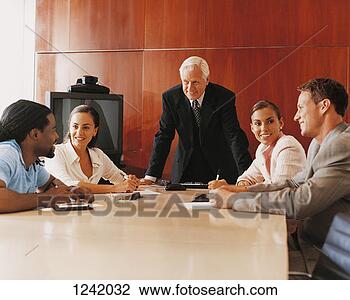 Stock Photo - mature ceo standing 
at the end of 
a conference table 
in a room with. 
fotosearch - search 
stock photos, 
pictures, images, 
and photo clipart