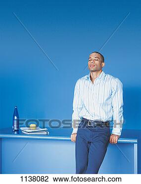 Stock Photo - serene, young 
businessman leaning 
against a table 
with his eyes 
closed. fotosearch 
- search stock 
photos, pictures, 
images, and photo 
clipart