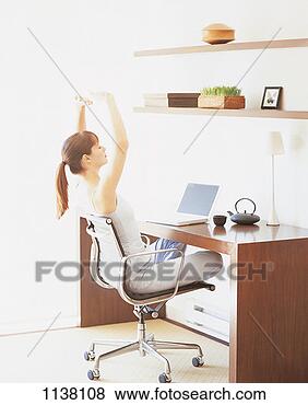 Stock Photo - side view of a 
young businesswoman 
stretching her 
arms and sitting. 
fotosearch - search 
stock photos, 
pictures, images, 
and photo clipart