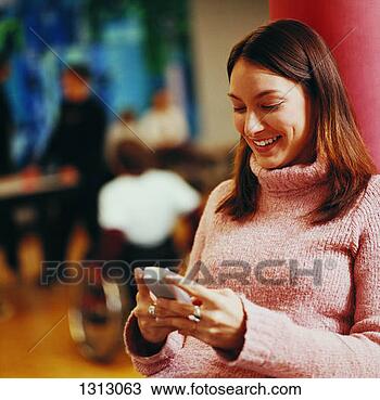 Stock Photo - female student 
reading a text 
message on her 
mobile phone. 
fotosearch - search 
stock photos, 
pictures, images, 
and photo clipart