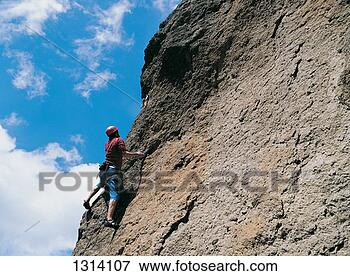 Picture - low angle shot 
of an adult climbing 
a rugged rock 
face. fotosearch 
- search stock 
photos, pictures, 
images, and photo 
clipart