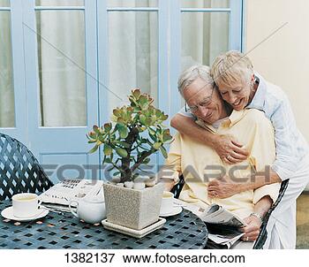 Picture - senior couple 
having tea in 
a courtyard and 
reading a newspaper. 
fotosearch - search 
stock photos, 
pictures, images, 
and photo clipart
