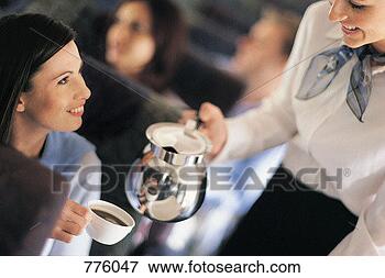 Picture - female passenger 
being served coffee 
by an air stewardess. 
fotosearch - search 
stock photos, 
pictures, images, 
and photo clipart