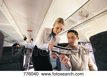 Stock Photography - male passenger 
showing his ticket 
to an air stewardess 
on an aeroplane. 
fotosearch - search 
stock photos, 
pictures, images, 
and photo clipart