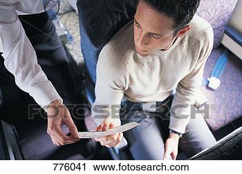 Stock Photography - male passenger 
showing his ticket 
to an air stewardess 
on an aeroplane. 
fotosearch - search 
stock photos, 
pictures, images, 
and photo clipart