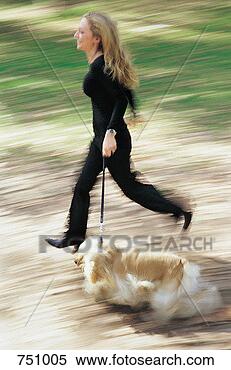 Stock Image - woman running 
in a park with 
her cavalier king 
charles spaniel. 
fotosearch - search 
stock photos, 
pictures, images, 
and photo clipart