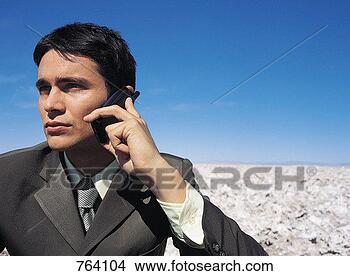 Stock Photo - portrait of a 
businessman using 
a mobile phone 
in the desert. 
fotosearch - search 
stock photos, 
pictures, images, 
and photo clipart