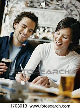 Stock Photo - man sitting next 
to a woman in 
a pub while she 
is writing. fotosearch 
- search stock 
photos, pictures, 
images, and photo 
clipart