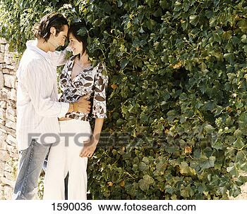 Stock Photo - young couple stand 
by a stone wall 
embracing. fotosearch 
- search stock 
photos, pictures, 
images, and photo 
clipart