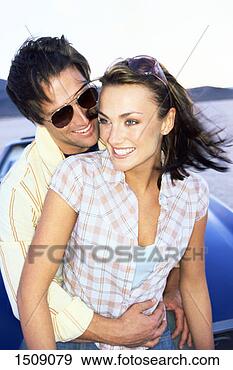 Stock Photograph - couple embrace 
on the bonnet 
of a stationary 
car in the desert. 
fotosearch - search 
stock photos, 
pictures, images, 
and photo clipart