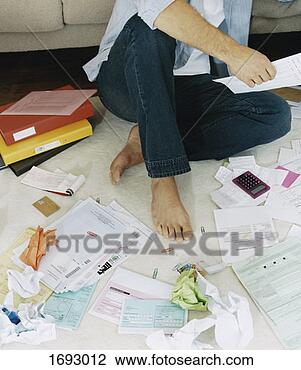 Stock Photo - elevated view 
of a man sitting 
on a rug surrounded 
by bills. fotosearch 
- search stock 
photos, pictures, 
images, and photo 
clipart