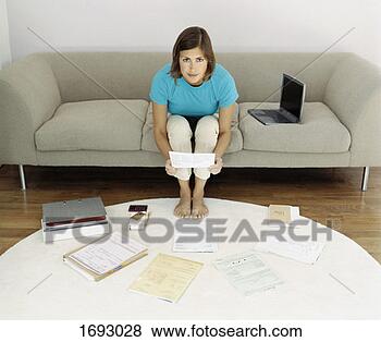 Stock Photo - elevated view 
of a woman sitting 
on a sofa surrounded 
by bills. fotosearch 
- search stock 
photos, pictures, 
images, and photo 
clipart