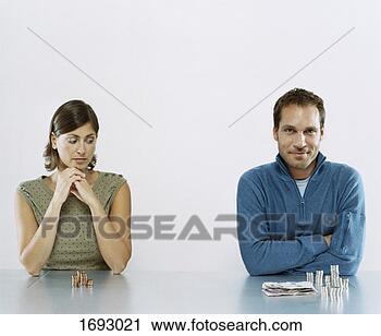 Stock Photography - man and woman 
sit next to each 
other with a pile 
of money in front 
of. fotosearch 
- search stock 
photos, pictures, 
images, and photo 
clipart