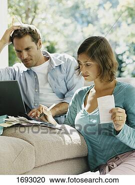 Stock Photography - serious looking 
couple examining 
their bills. fotosearch 
- search stock 
photos, pictures, 
images, and photo 
clipart