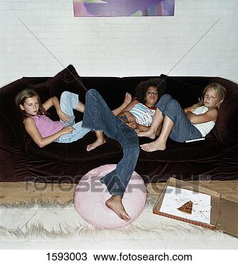 Stock Photo - three bored girls 
lying on a brown 
sofa watching 
tv. fotosearch 
- search stock 
photos, pictures, 
images, and photo 
clipart