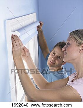 Stock Photography - couple hanging 
blue blinds on 
a window. fotosearch 
- search stock 
photos, pictures, 
images, and photo 
clipart