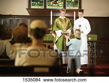 Stock Photo - anglican congregation 
watching a woman 
receive communion 
from a priest. 
fotosearch - search 
stock photos, 
pictures, images, 
and photo clipart