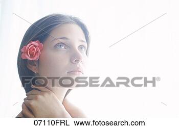 Stock Photo - woman with rose 
tucked behind 
her ear, looking 
up. fotosearch 
- search stock 
photos, pictures, 
images, and photo 
clipart