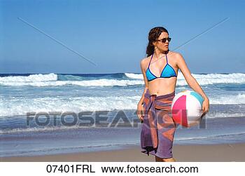 Stock Photo - woman walking 
on beach with 
beach ball. fotosearch 
- search stock 
photos, pictures, 
images, and photo 
clipart