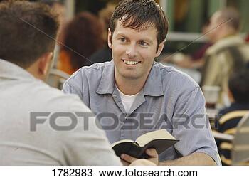 Stock Photo - man sharing from 
a book. fotosearch 
- search stock 
photos, pictures, 
images, and photo 
clipart