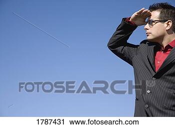 Stock Photography - a man shields 
his eyes from 
the sun and looks 
into the distance. 
fotosearch - search 
stock photos, 
pictures, images, 
and photo clipart