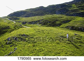 Stock Image - man walking on 
hillside. fotosearch 
- search stock 
photos, pictures, 
images, and photo 
clipart