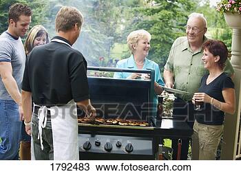 Stock Photo - man barbecuing 
burgers and talking 
with group of 
people. fotosearch 
- search stock 
photos, pictures, 
images, and photo 
clipart