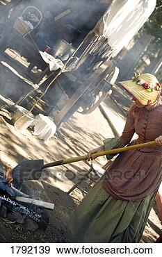 Stock Photograph - woman in old-fashioned 
clothing with 
shovel tending 
to fire. fotosearch 
- search stock 
photos, pictures, 
images, and photo 
clipart