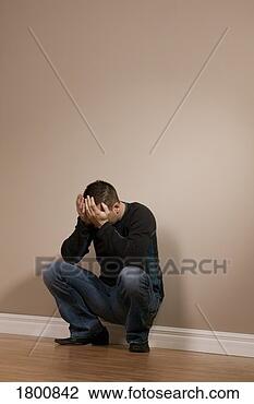 Stock Photo - man crouching 
with hands over 
face. fotosearch 
- search stock 
photos, pictures, 
images, and photo 
clipart