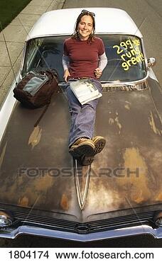 Stock Photo - high angle view 
of a girl leaning 
over car bonnet. 
fotosearch - search 
stock photos, 
pictures, images, 
and photo clipart