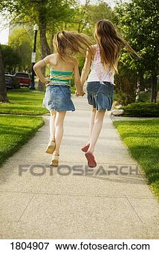 Picture - rear view of girls 
running on sidewalk. 
fotosearch - search 
stock photos, 
pictures, images, 
and photo clipart