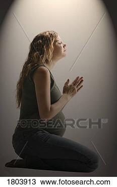 Stock Photo - side view of a 
pensive pregnant 
woman sitting 
in the prayer 
position. fotosearch 
- search stock 
photos, pictures, 
images, and photo 
clipart
