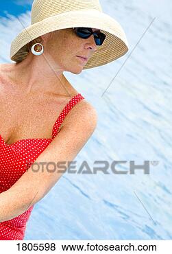 Stock Photo - woman at the pool 
wearing sunglasses 
and sun hat. fotosearch 
- search stock 
photos, pictures, 
images, and photo 
clipart