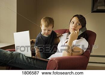 Picture - mother on the 
phone with laptop 
and child on her 
lap. fotosearch 
- search stock 
photos, pictures, 
images, and photo 
clipart