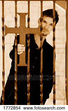 Stock Photo - man holding cross 
on iron fence. 
fotosearch - search 
stock photos, 
pictures, images, 
and photo clipart