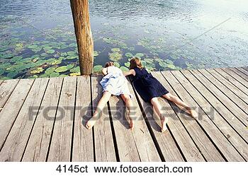 Stock Photo - children lying 
on jetty, looking 
water. fotosearch 
- search stock 
photos, pictures, 
images, and photo 
clipart