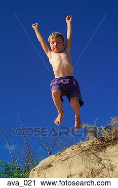 Stock Photography - young boy jumping 
off sand dune. 
fotosearch - search 
stock photos, 
pictures, images, 
and photo clipart