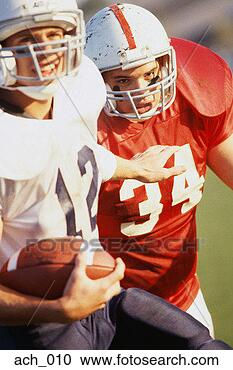 Stock Photography - football player 
holding ball, 
being chased by 
opponent. fotosearch 
- search stock 
photos, pictures, 
images, and photo 
clipart