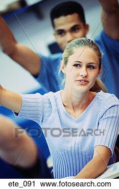 Stock Photography - girl raising hand 
in class; boy 
behind her raising 
both hands. fotosearch 
- search stock 
photos, pictures, 
images, and photo 
clipart