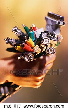 Picture - hand holding assortment 
of plugs, jacks 
and cables. fotosearch 
- search stock 
photos, pictures, 
images, and photo 
clipart
