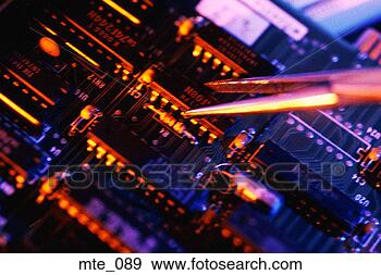 Stock Photograph - tweezers holding 
microchip, about 
to install it 
on circuit board. 
fotosearch - search 
stock photos, 
pictures, images, 
and photo clipart