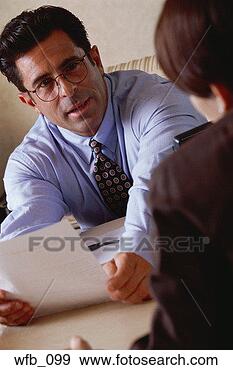 Stock Photograph - man talking to 
woman in office, 
holding piece 
of paper. fotosearch 
- search stock 
photos, pictures, 
images, and photo 
clipart