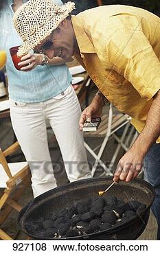 Stock Photo - man lighting barbecue. 
fotosearch - search 
stock photos, 
pictures, images, 
and photo clipart