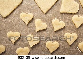 Stock Image - cut-out biscuits 
on baking parchment. 
fotosearch - search 
stock photos, 
pictures, images, 
and photo clipart