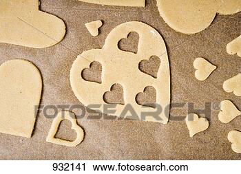 Stock Photography - cut-out heart-shaped 
biscuits on baking 
parchment. fotosearch 
- search stock 
photos, pictures, 
images, and photo 
clipart