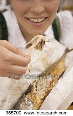 Stock Photography - woman eating steckerlfisch 
(fish on stick, 
oktoberfest, munich). 
fotosearch - search 
stock photos, 
pictures, images, 
and photo clipart