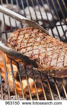 Stock Photography - beef steak on 
a barbecue with 
barbecue tongs. 
fotosearch - search 
stock photos, 
pictures, images, 
and photo clipart